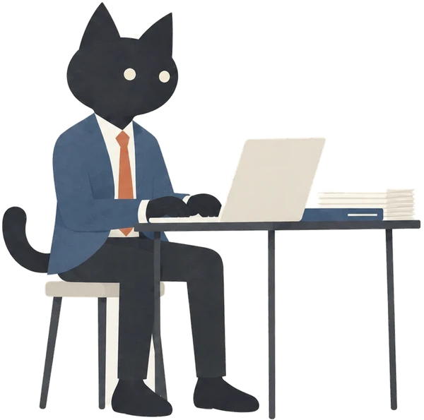 小さな机でノートPCに向かい、記事を入稿するAIMAの黒猫